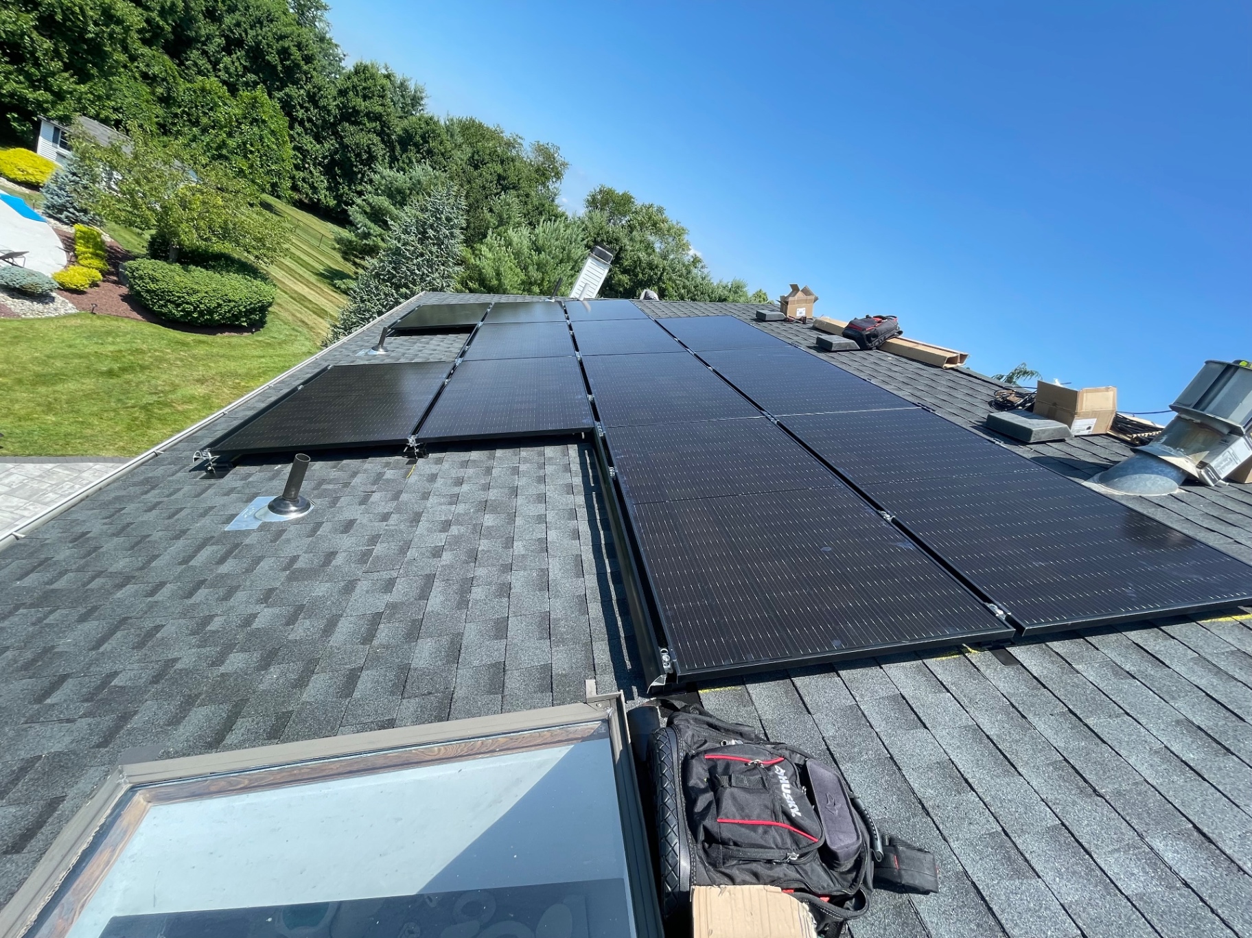 12 panel solar installation in progress on a grey shingle roof in Manalapan, New Jersey