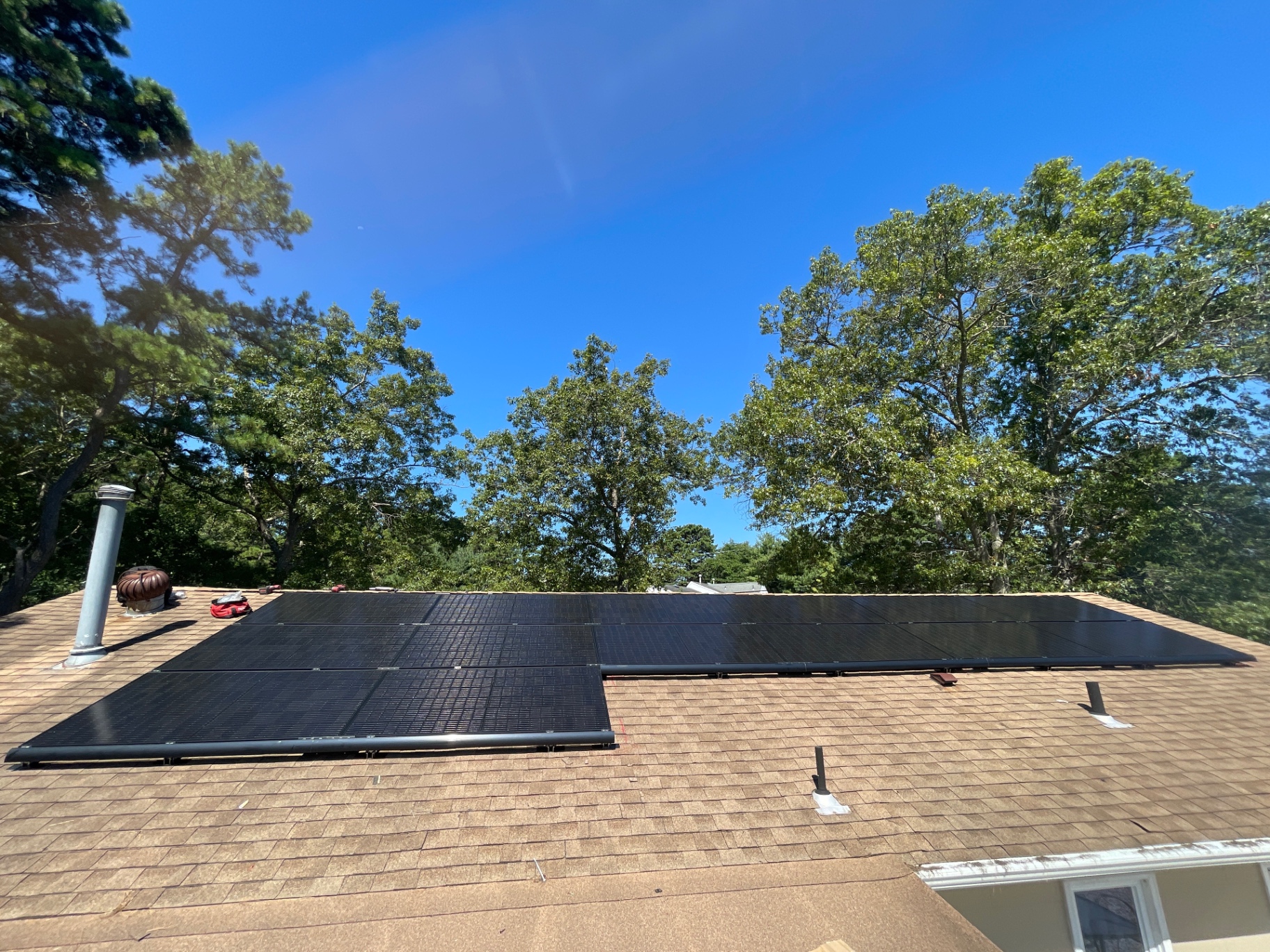 14 panel black solar array installed on a tan shingle roof in Monroe Township, New Jersey