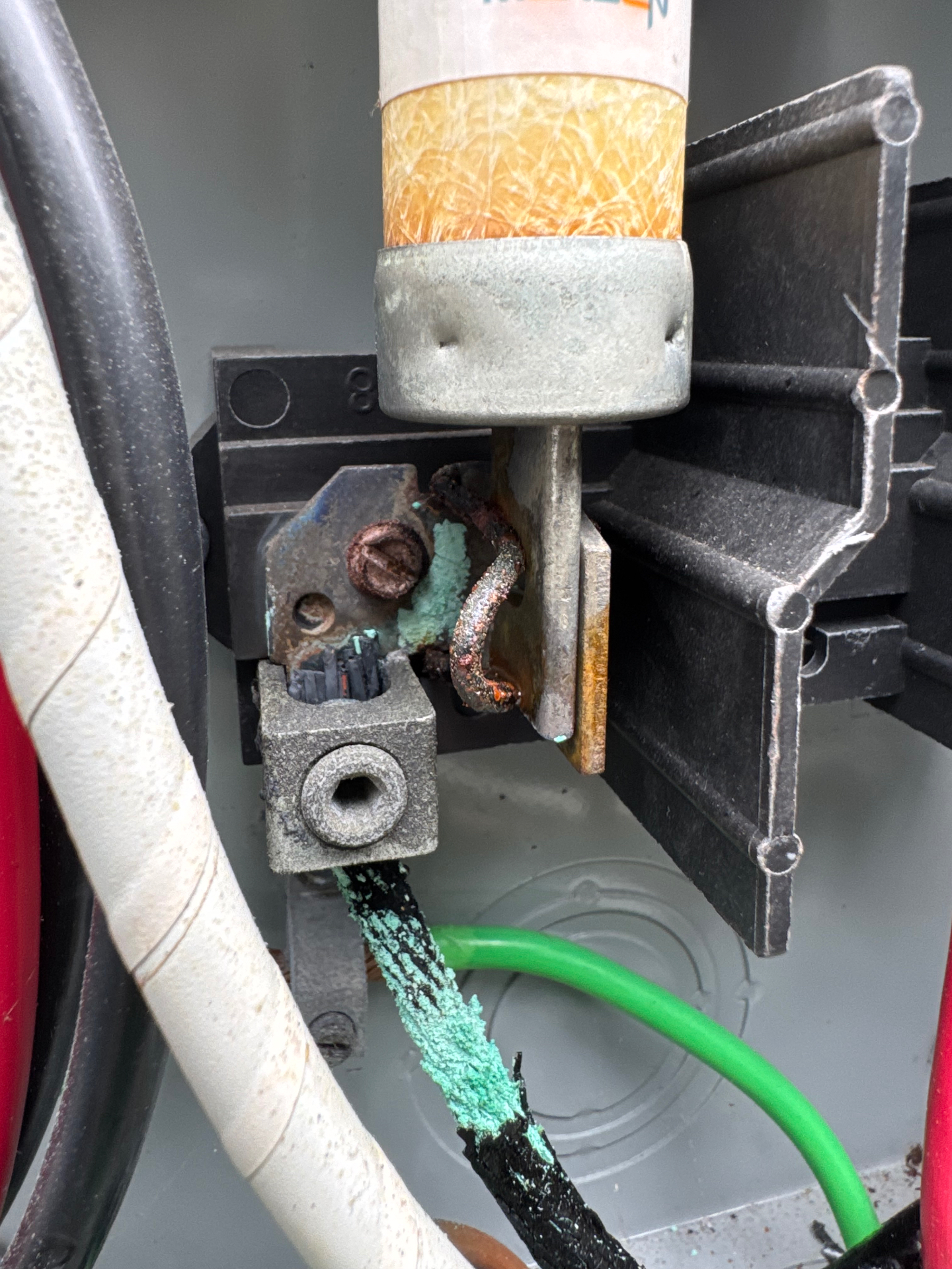Close-up of a corroded 60 amp solar disconnect showing green oxidized copper wiring and a rusted lug during troubleshooting