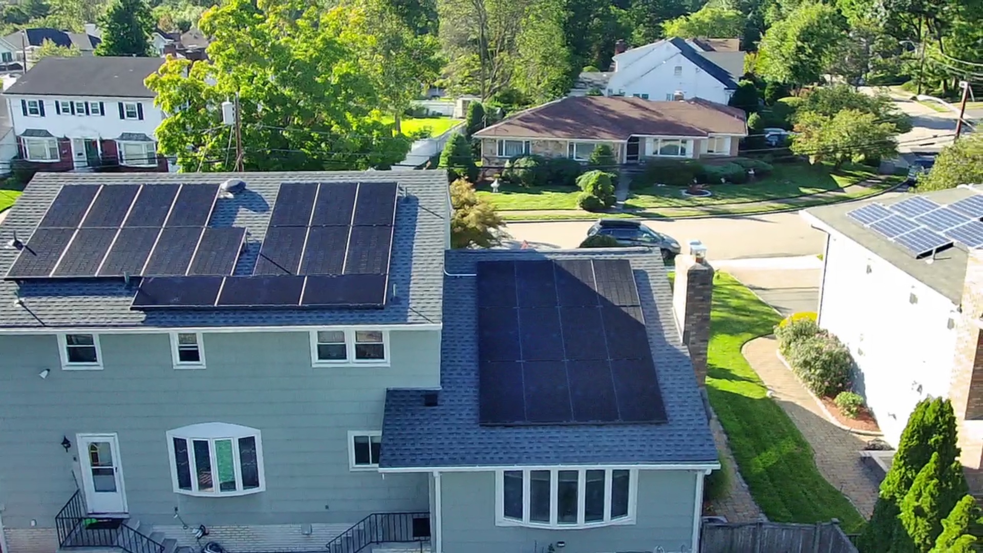 Aerial view of a 30 panel black solar array installed across two roof sections of a home in Millstone, New Jersey
