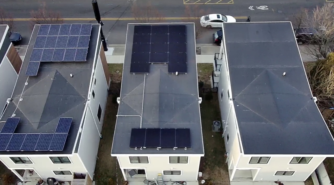 Aerial view of a 35 panel solar installation across flat-roof townhomes in Asbury Park, New Jersey